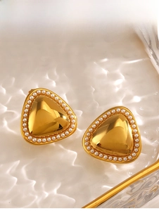 Vue détaillée de boucles d'oreilles triangle dorées avec perles sur plateau