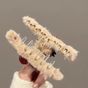 Plush beige shark hair claw clip with cherry decor for thick hair shown from side view