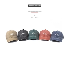 Detailed view of washed cotton baseball caps in five vintage colors with dog embroidery
