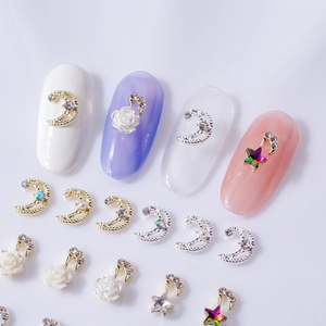 Star, moon, and rose nail art charms set with rhinestones and pearls on a metal base