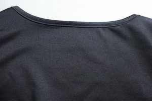 Détail de l'encolure d'un haut noir en tricot avec des coutures précises et un tissu de qualité