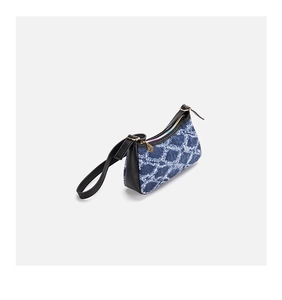 Close-up of blue denim pattern shoulder bag with black leather trim and gold zippers