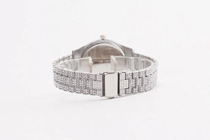 Close-up of luxury women's silver watch with sparkling crystal encrusted bezel and metal strap