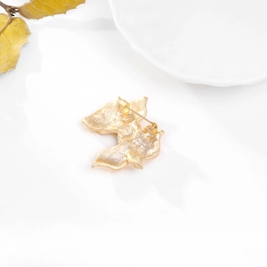 Elegant gold butterfly brooch with a secure pin clasp shown on a minimalist white background
