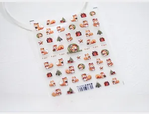 Macro view of Christmas nail stickers featuring squirrels, trees, and gift patterns