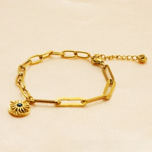 Detailed close-up of a 18K gold-plated paperclip chain bracelet with a starburst sun pendant