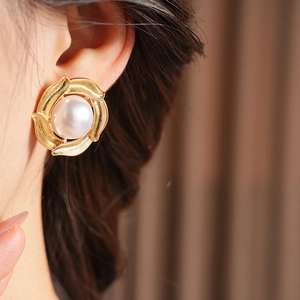 Close-up of pearl and gold circle earrings worn by a model in vintage aesthetic style