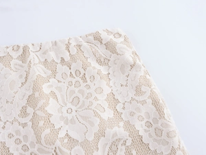 Close-up of white lace fabric with intricate floral patterns and textured weaving