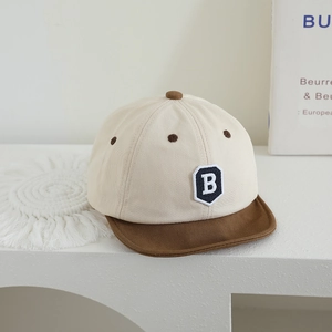Detailed close-up of a soft-brim baby baseball cap with an embroidered letter B patch