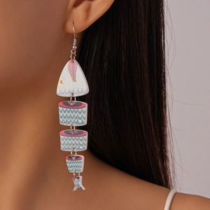 Close-up of bohemian fishbone drop earrings with colorful prints on a female model