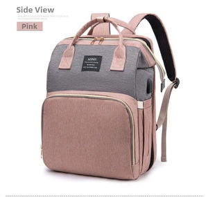 Detailed view of pink and grey diaper bag showing USB charging port and side bottle pocket