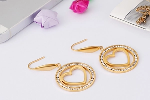 Detail of gold heart earrings with rhinestone circle and elegant fishhook design