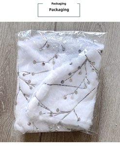 Detailed view of white faux fur Christmas tree skirt with silver sequins in packaging