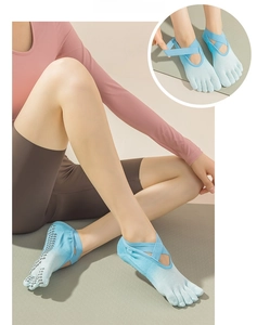 Detail of tie-dye five-toe yoga socks with crisscross straps and anti-slip heart grips