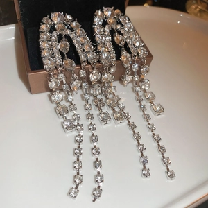 Close-up of silver tassel earrings with sparkling rhinestones on a jewelry box