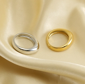 Close-up of gold and silver stainless steel rings on premium golden silk fabric background