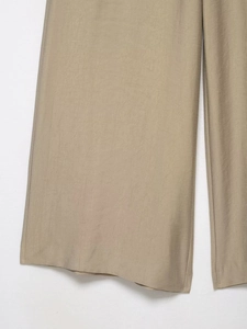 Detail of khaki wide-leg pants showing the woven linen-like fabric texture and quality
