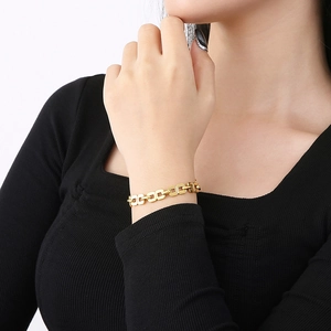 Vue détaillée d'un bracelet doré à maillons géométriques sur le poignet d'un mannequin