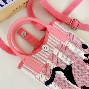 Detail of pink knitted bag handle and magnetic closure with flamingo pattern