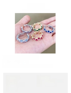 Detail view of adjustable copper rings featuring colorful synthetic gemstones and zircons