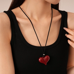 Vintage red heart pendant necklace with black cord cord on a female model neck