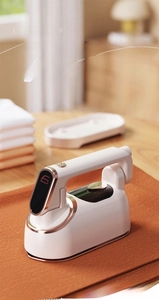 Detail of white portable handheld garment steamer with digital display and rose gold trim