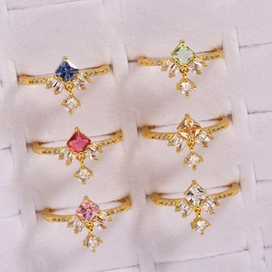 Detailed set of gold rings with colorful square stones and delicate dangling charms