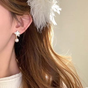 Close-up of 14K gold plated starburst stud earrings with elegant hanging white pearl