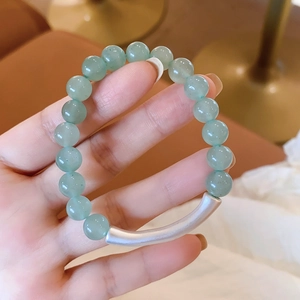 Detail of green aventurine beaded bracelet with matte silver curved metal tube detail