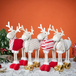 Set of four plush Christmas reindeer dolls with long legs on snow for festive decoration