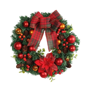 Christmas wreath with red bow, golden balls, pine cones, and berries on green needles
