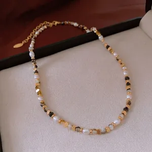 Vintage freshwater pearl necklace with tiger eye beads and gold clasp on a jewelry box