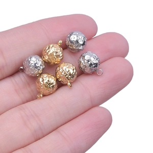 304 stainless steel hammered texture ball charms in 18k gold and silver held in hand