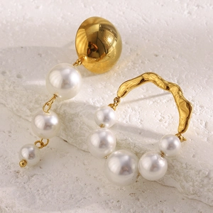 Detailed view of asymmetric 18K gold plated earrings with white pearls on white stone