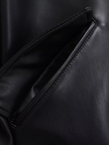 Gros plan détaillé sur la texture du similicuir noir et les coutures de précision de la poche