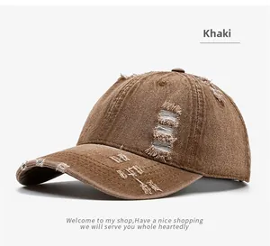 Detail of distressed khaki washed denim baseball cap with embroidery and frayed holes