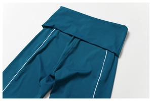 Détail du legging de yoga sarcelle à taille haute avec surpiqûres blanches contrastées