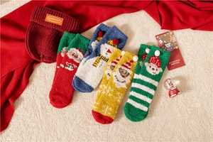 Flat lay of four colorful Christmas coral fleece socks with a burgundy knitted hat