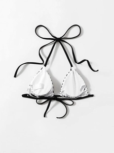 Detail view of the white inner lining and wash label on a black and white bikini top