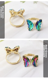 Detail of adjustable butterfly rings in iridescent blue-green and red-green crystal