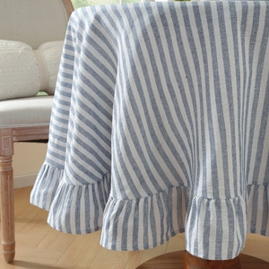 Detail of blue and white striped cotton linen tablecloth with elegant ruffled edge