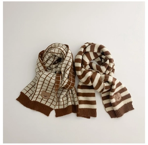 Detail of kids knit scarf with bear embroidery in beige and brown check and stripe patterns