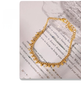 Detailed macro view of 18k gold plated stainless steel bead bracelet with crystal charm
