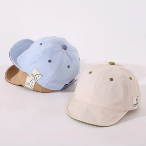 Detail of infant soft brim baseball caps with Good Luck letter patches in three soft colors