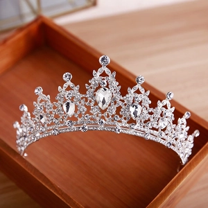 Sparkling crystal princess crown with silver plating and teardrop stones in a wood tray