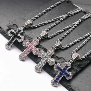 Detailed view of four cross pendants with colorful stones on twisted silver chains