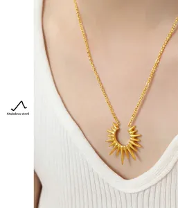 Detail of a radiant geometric sunburst pendant on a gold-plated stainless steel chain