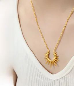 Detail of a radiant geometric sunburst pendant on a gold-plated stainless steel chain