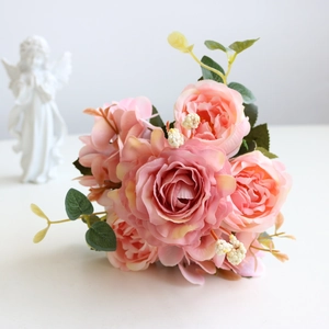Detailed view of pink silk artificial rose bouquet with lifelike petals and green leaves