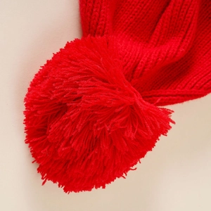 Close-up of red Christmas knit hat showing warm wool texture and soft pompom detail